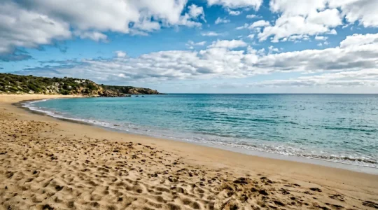 Feinsandiger Strand mit türkisblauem Wasser und sanften Wellen für perfekten Strandurlaub