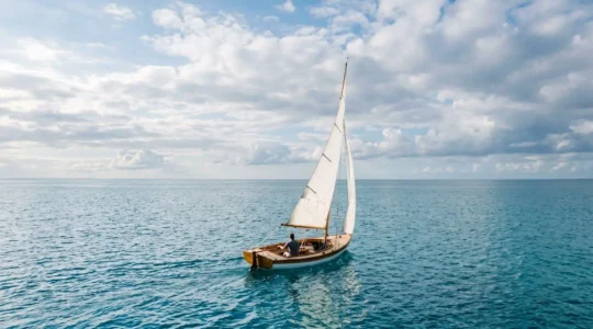 Segelboot gleitet lautlos über ruhiges Wasser mit Wind in den Segeln